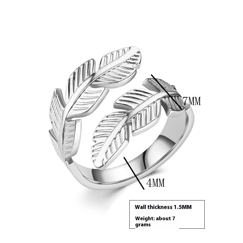 Silver feather-shaped ring with measurements on a white background