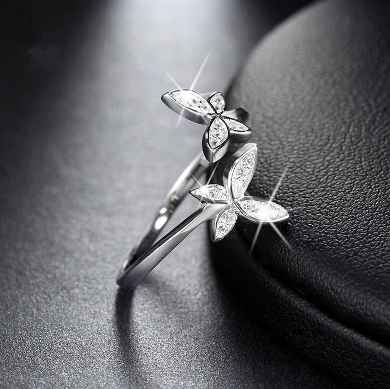 Silver butterfly ring on a dark textured surface