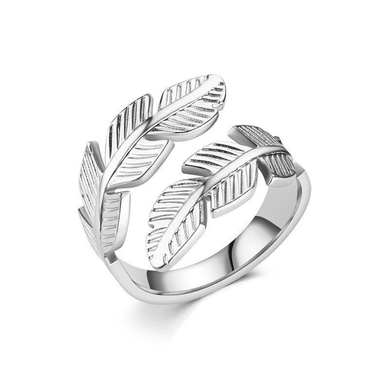 Silver ring with feather design on a white background